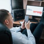 Business owner. Man working online in the office with multiple computer screens in index charts