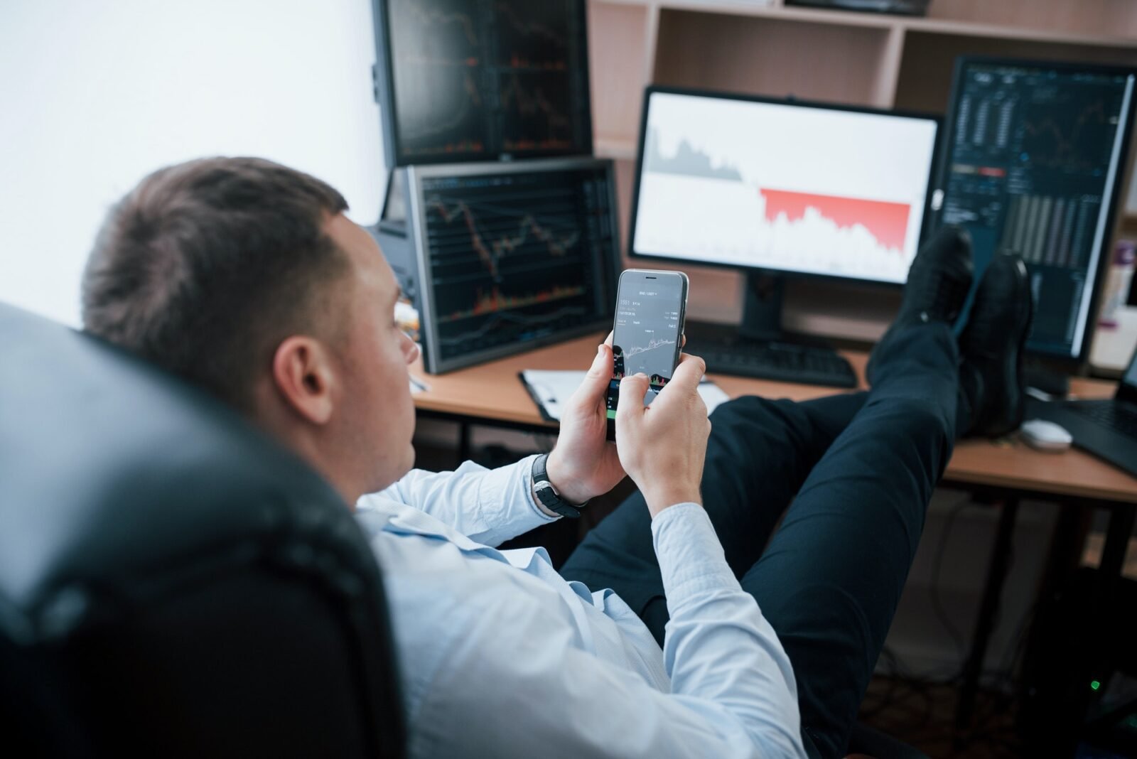 Business owner. Man working online in the office with multiple computer screens in index charts