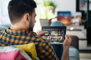 Man Choosing Movie For Streaming On Tablet