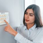 Woman is indoors controlling smart home technology